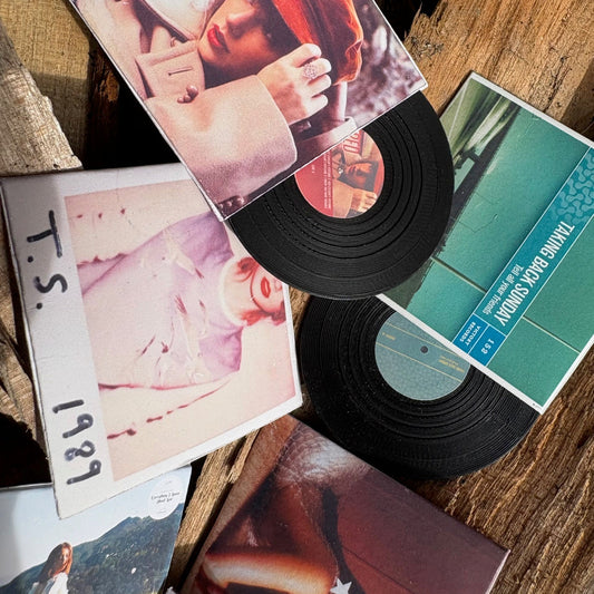 Miniature Vinyl records and their covers on a wooden surface